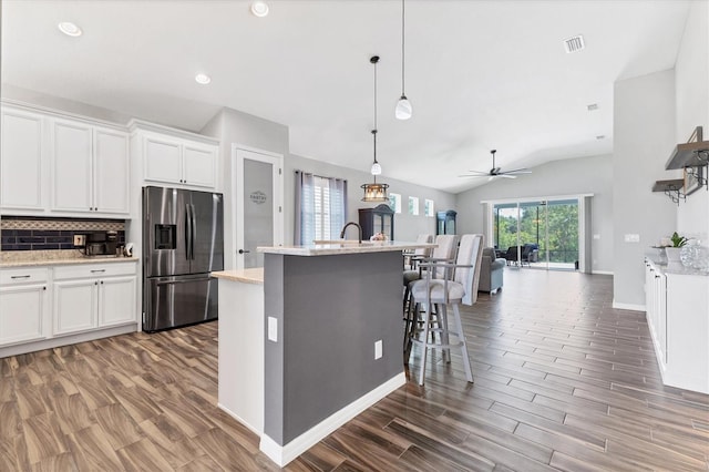 12755 Rainwashed Loop, Parrish, FL 34219 - kitchen with stainless steel refrigerator with ice dispenser, lofted ceiling, wood finished floors, open floor plan, and tasteful backsplash