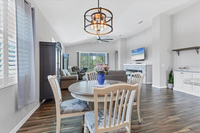 12755 Rainwashed Loop, Parrish, FL 34219 - dining room featuring a chandelier, a stone fireplace, baseboards, arched walkways, and dark wood-style flooring