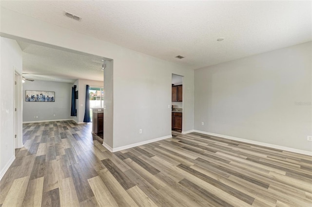 1721 Palm Warbler Ln, Ruskin, FL 33570 - unfurnished room with a textured ceiling, light wood-type flooring, and baseboards