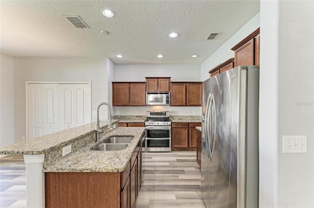1721 Palm Warbler Ln, Ruskin, FL 33570 - kitchen featuring stainless steel appliances, a sink, light wood-style flooring, recessed lighting, and a center island with sink