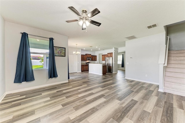 1721 Palm Warbler Ln, Ruskin, FL 33570 - unfurnished living room with plenty of natural light, a chandelier, light wood-style flooring, a ceiling fan, and recessed lighting