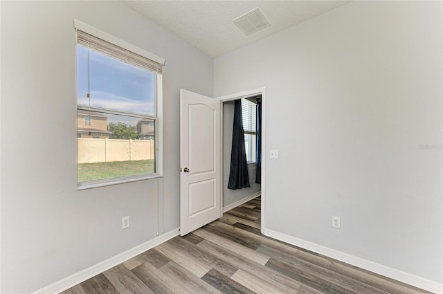 1721 Palm Warbler Ln, Ruskin, FL 33570 - unfurnished room with wood finished floors, baseboards, and a textured ceiling
