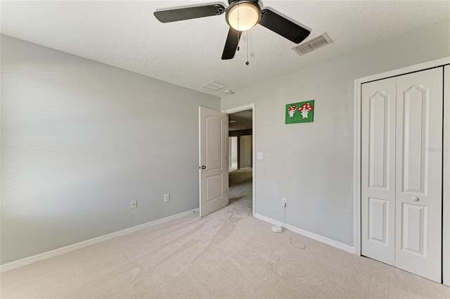 1721 Palm Warbler Ln, Ruskin, FL 33570 - unfurnished bedroom featuring light colored carpet, a textured ceiling, a closet, baseboards, and ceiling fan