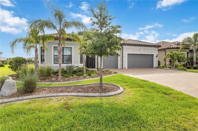 7327 Summerland Cv, Bradenton, FL 34202 - mediterranean / spanish-style house with an attached garage, driveway, a front yard, and stucco siding