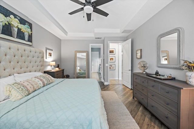 13819 American Prairie Pl, Bradenton, FL 34211 - bedroom with a tray ceiling, baseboards, dark wood-style floors, and a ceiling fan