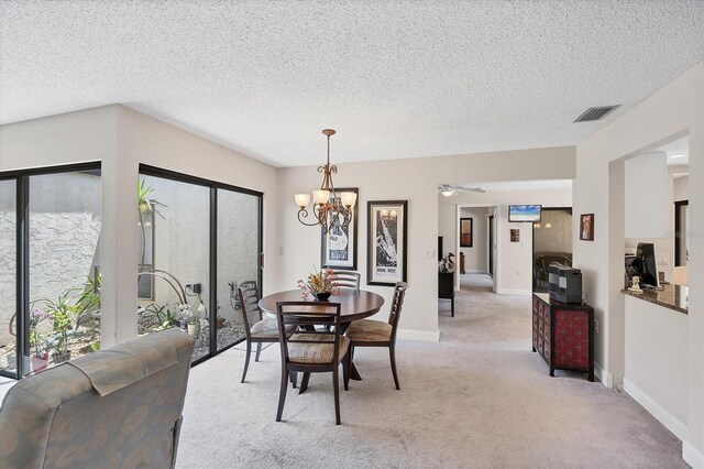 3914 Glen Oaks Manor Dr, Sarasota, FL 34232 - dining space with light carpet, a chandelier, baseboards, and a textured ceiling