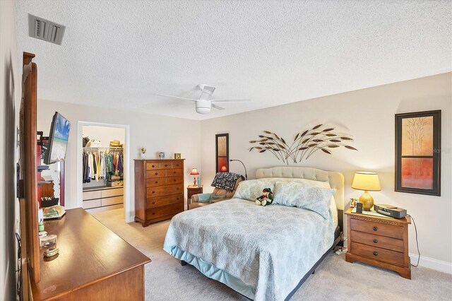 3914 Glen Oaks Manor Dr, Sarasota, FL 34232 - bedroom featuring light colored carpet, a walk in closet, a textured ceiling, a closet, and a ceiling fan