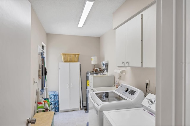 3914 Glen Oaks Manor Dr, Sarasota, FL 34232 - laundry room featuring washer and clothes dryer, cabinet space, and light tile patterned floors