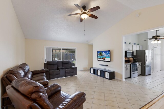 613 E 49th St E, Bradenton, FL 34208 - living room with ceiling fan, light tile patterned floors, high vaulted ceiling, baseboards, and a textured ceiling