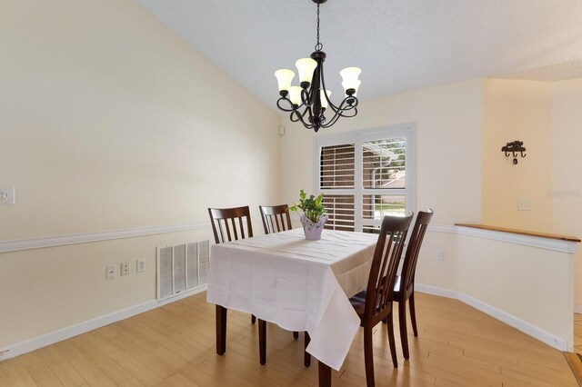 613 E 49th St E, Bradenton, FL 34208 - dining room featuring a chandelier, light wood-type flooring, and baseboards