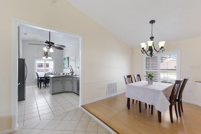 613 E 49th St E, Bradenton, FL 34208 - dining room featuring vaulted ceiling, a chandelier, healthy amount of natural light, light tile patterned floors, and a ceiling fan