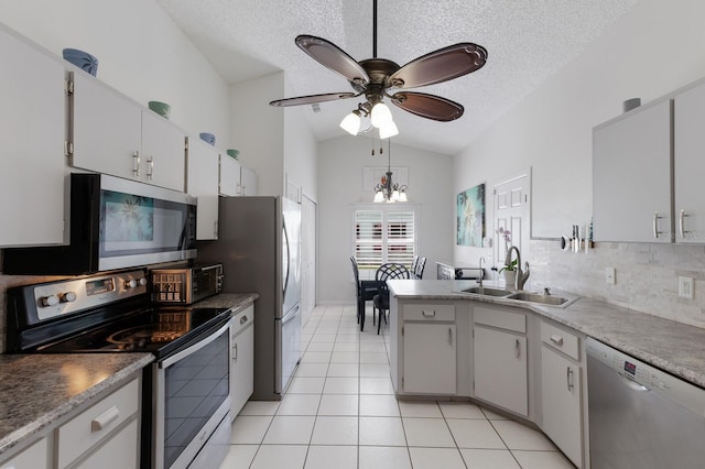 613 E 49th St E, Bradenton, FL 34208 - kitchen featuring stainless steel appliances, vaulted ceiling, a sink, light tile patterned flooring, and ceiling fan