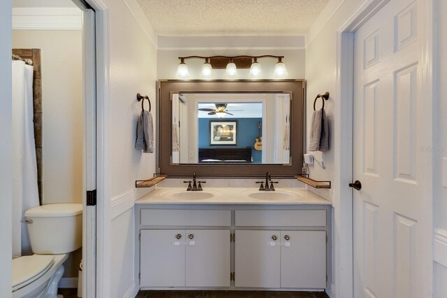 613 E 49th St E, Bradenton, FL 34208 - full bathroom featuring double vanity, toilet, a textured ceiling, and ceiling fan
