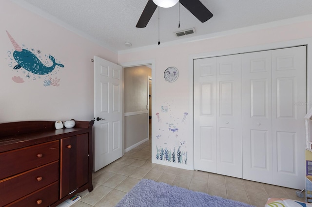 613 E 49th St E, Bradenton, FL 34208 - bedroom with light tile patterned floors, a closet, ceiling fan, and a textured ceiling