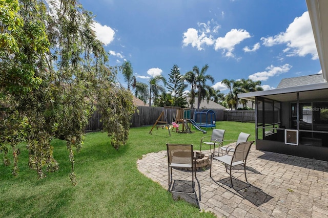 613 E 49th St E, Bradenton, FL 34208 - view of yard featuring a sunroom, a trampoline, a patio area, and a playground