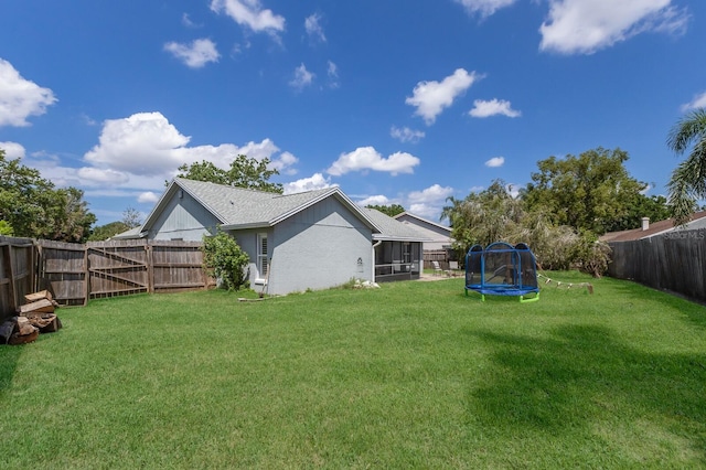 613 E 49th St E, Bradenton, FL 34208 - view of yard featuring a trampoline and a sunroom