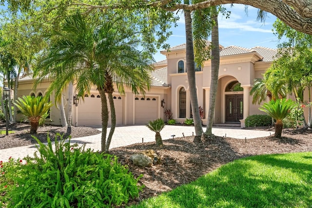 6808 Belmont Ct, Lakewood Ranch, FL 34202 - mediterranean / spanish-style home featuring a tile roof, french doors, an attached garage, and stucco siding