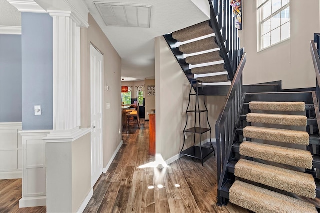 2306 63rd St W Unit 40, Bradenton, FL 34209 - stairway with ornate columns, wood finished floors, and a wainscoted wall