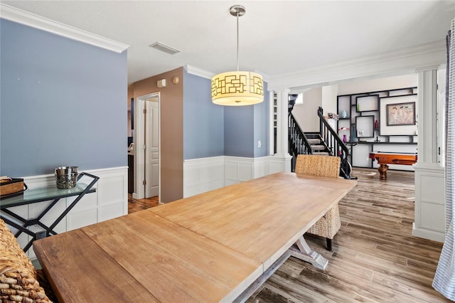 2306 63rd St W Unit 40, Bradenton, FL 34209 - dining room featuring ornamental molding, a wainscoted wall, stairway, wood finished floors, and ornate columns