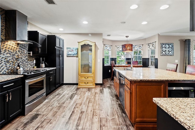 2306 63rd St W Unit 40, Bradenton, FL 34209 - kitchen with appliances with stainless steel finishes, light wood-type flooring, light stone counters, a sink, and tasteful backsplash
