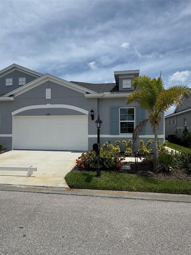 24831 Buckingham Way, Port Charlotte, FL 33980 - view of front facade featuring driveway, a garage, and stucco siding