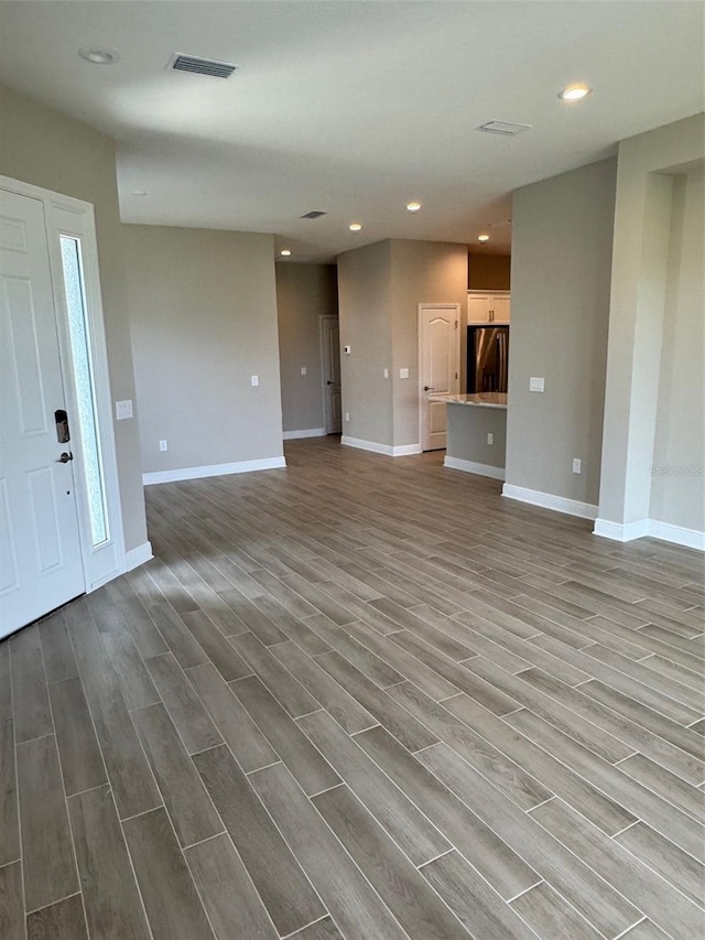 24831 Buckingham Way, Port Charlotte, FL 33980 - unfurnished living room featuring wood finished floors, baseboards, and recessed lighting
