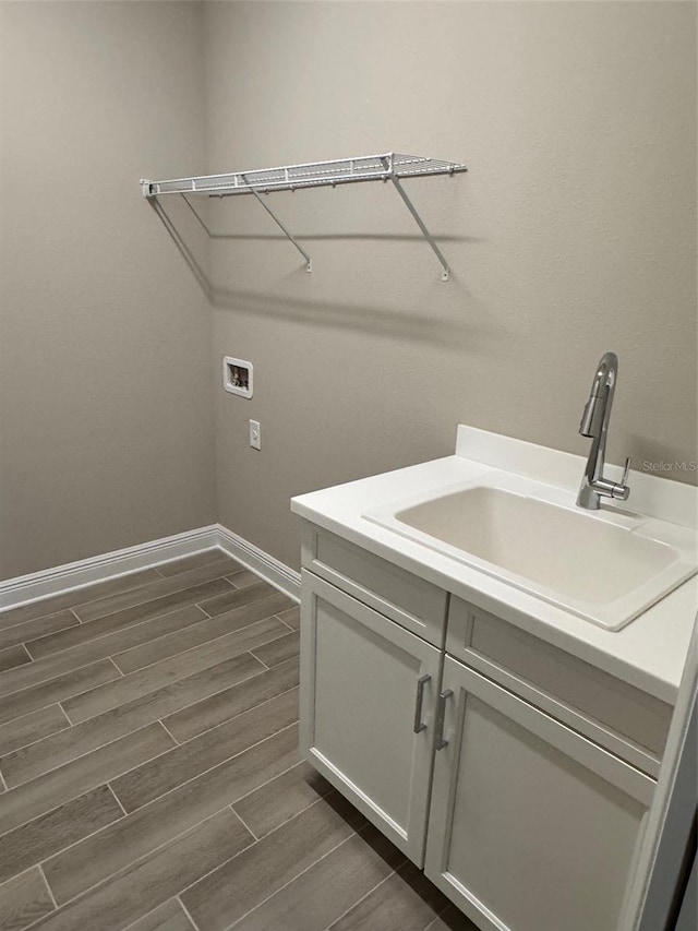 24831 Buckingham Way, Port Charlotte, FL 33980 - laundry area featuring washer hookup, wood tiled floors, baseboards, and cabinet space