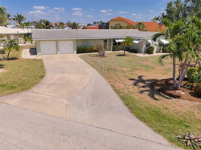 135 Gulfview Rd, Punta Gorda, FL 33950 - view of front of home with a tile roof, a front yard, driveway, a garage, and stucco siding