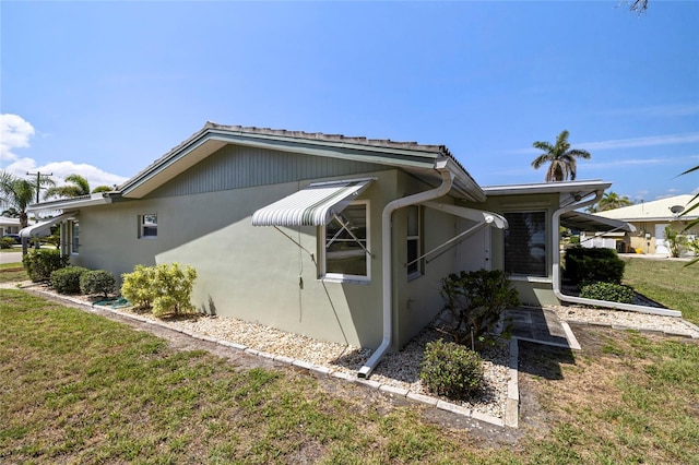 135 Gulfview Rd, Punta Gorda, FL 33950 - view of side of home with a lawn and stucco siding