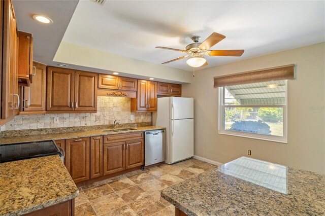 135 Gulfview Rd, Punta Gorda, FL 33950 - kitchen with freestanding refrigerator, brown cabinetry, tasteful backsplash, dishwasher, and baseboards