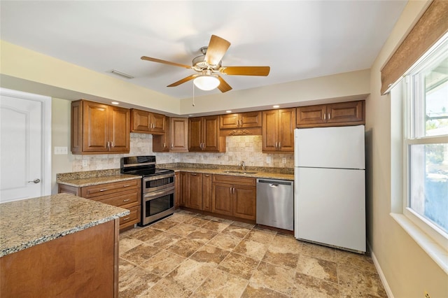 135 Gulfview Rd, Punta Gorda, FL 33950 - kitchen with appliances with stainless steel finishes, a sink, brown cabinets, and backsplash