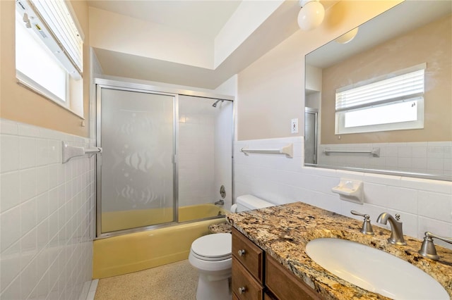 135 Gulfview Rd, Punta Gorda, FL 33950 - full bathroom featuring tile walls, toilet, wainscoting, vanity, and enclosed tub / shower combo