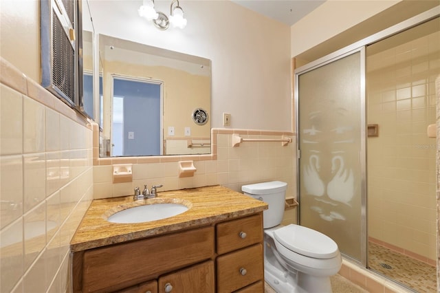 135 Gulfview Rd, Punta Gorda, FL 33950 - bathroom with a shower stall, toilet, vanity, tile walls, and wainscoting
