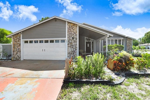 7321 Caladesia Dr, Sarasota, FL 34243 - view of front of house with stone siding, driveway, a ceiling fan, and an attached garage
