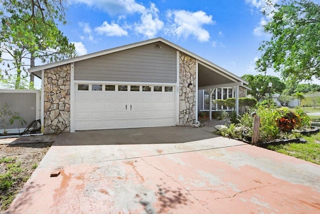 7321 Caladesia Dr, Sarasota, FL 34243 - mid-century modern home with stone siding, driveway, and an attached garage