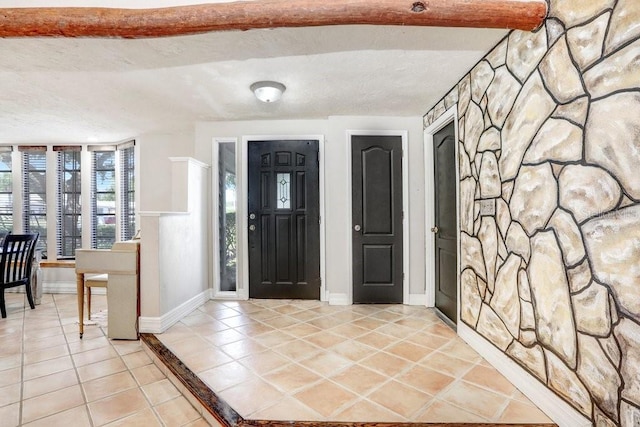 7321 Caladesia Dr, Sarasota, FL 34243 - entryway with light tile patterned flooring, a textured ceiling, and baseboards