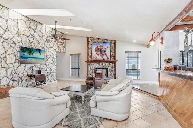 7321 Caladesia Dr, Sarasota, FL 34243 - living area featuring a stone fireplace, light tile patterned flooring, a skylight, baseboards, and vaulted ceiling