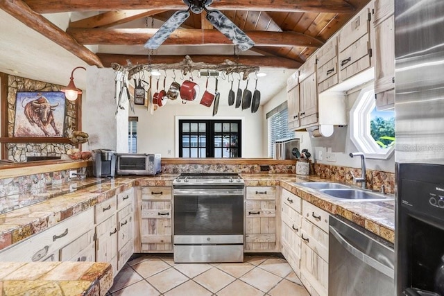 7321 Caladesia Dr, Sarasota, FL 34243 - kitchen featuring stainless steel appliances, a sink, beam ceiling, light tile patterned floors, and tile counters