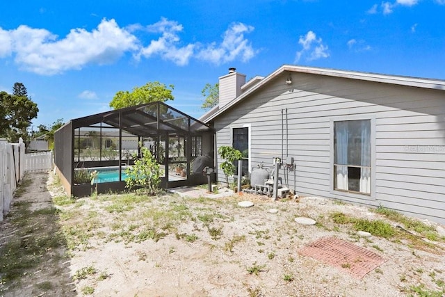 7321 Caladesia Dr, Sarasota, FL 34243 - back of property featuring a fenced backyard, a chimney, and glass enclosure