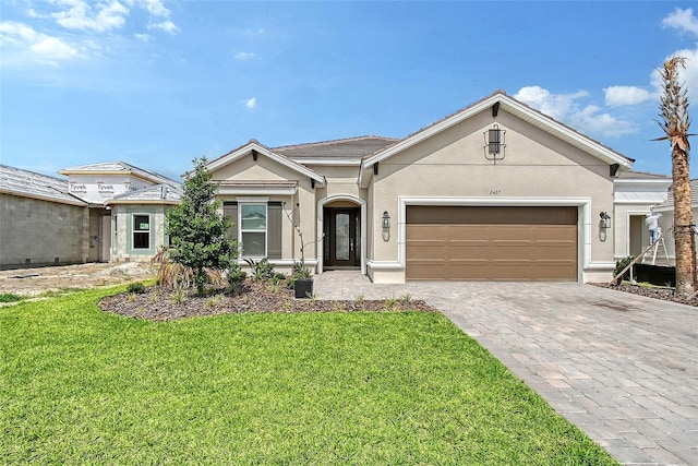 11427 Viani Ter, Palmetto, FL 34221 - ranch-style home with stucco siding, an attached garage, a front yard, and decorative driveway