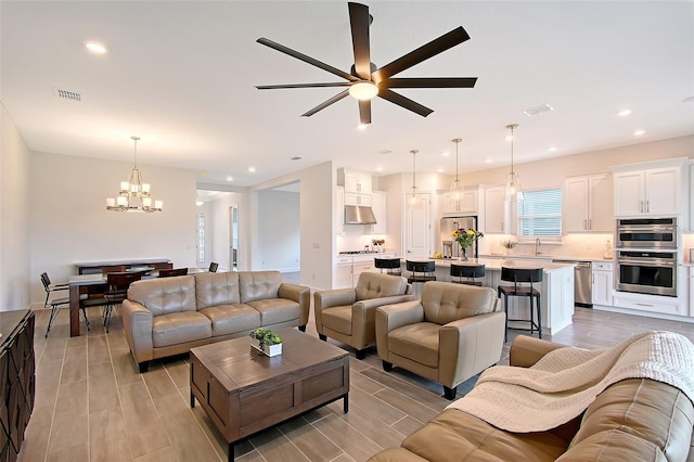 11427 Viani Ter, Palmetto, FL 34221 - living room featuring a chandelier, a ceiling fan, recessed lighting, and wood finish floors