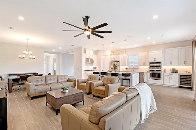 11427 Viani Ter, Palmetto, FL 34221 - living area with beverage cooler, a chandelier, ceiling fan, recessed lighting, and light wood-type flooring