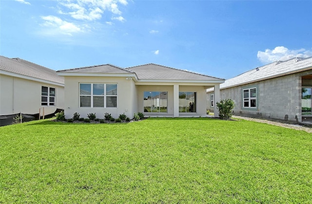 11427 Viani Ter, Palmetto, FL 34221 - rear view of property with a yard, stucco siding, and a tile roof