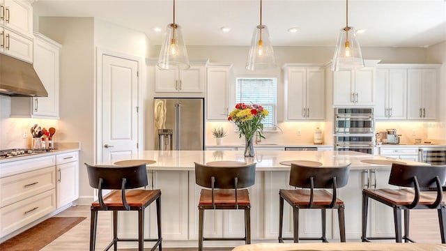 11427 Viani Ter, Palmetto, FL 34221 - kitchen with appliances with stainless steel finishes, under cabinet range hood, white cabinets, tasteful backsplash, and recessed lighting