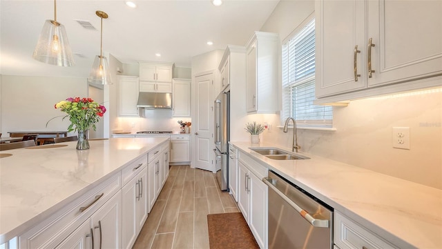 11427 Viani Ter, Palmetto, FL 34221 - kitchen with stainless steel appliances, a sink, under cabinet range hood, white cabinetry, and hanging light fixtures