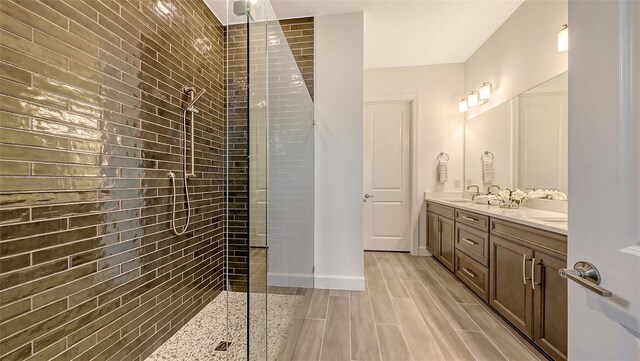 11427 Viani Ter, Palmetto, FL 34221 - full bath with double vanity, a tile shower, and wood finished floors