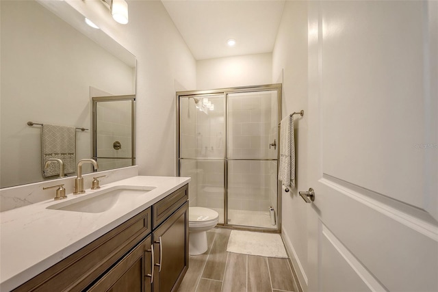 11427 Viani Ter, Palmetto, FL 34221 - bathroom featuring toilet, vanity, a stall shower, and wood finished floors