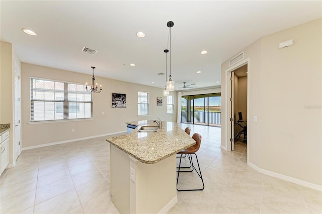 121 Porta Vecchio Bnd Unit 201, Nokomis, FL 34275 - kitchen featuring a sink, light tile patterned flooring, an island with sink, light stone counters, and a chandelier