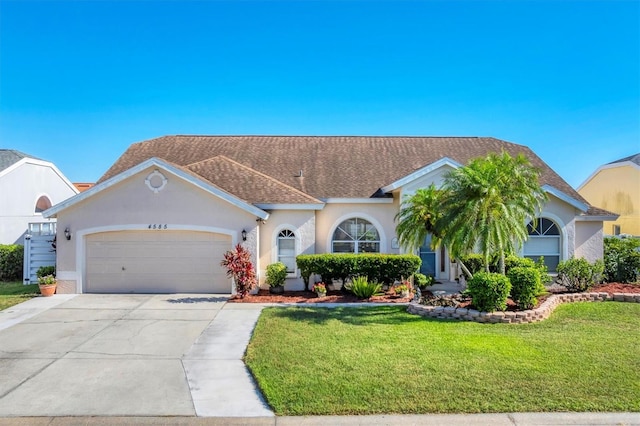 4585 Dover Street Cir E, Bradenton, FL 34203 - view of front of home with a front yard, an attached garage, stucco siding, driveway, and roof with shingles