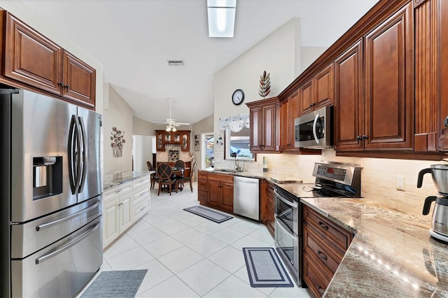 4585 Dover Street Cir E, Bradenton, FL 34203 - kitchen with stainless steel appliances, tasteful backsplash, a sink, vaulted ceiling, and light stone countertops
